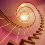 Spiralne schody z drewnianymi stopniami i metalową balustradą, loftowe wykończenie wnętrza